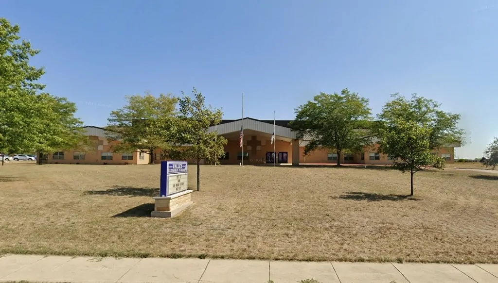 Front view of Valley Lutheran School with school sign and flagpole