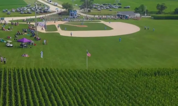 Aerial view of a baseball game on a lush field next to a cornfield