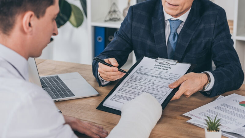 Injured employee reviews a workers’ compensation claim form with an adviser